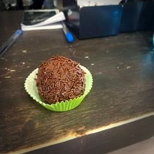 Un brigadeiro nel pirottino verde, sul tavolo di legno