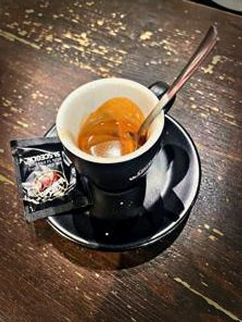 Un caffè al banco, sul piattino nero