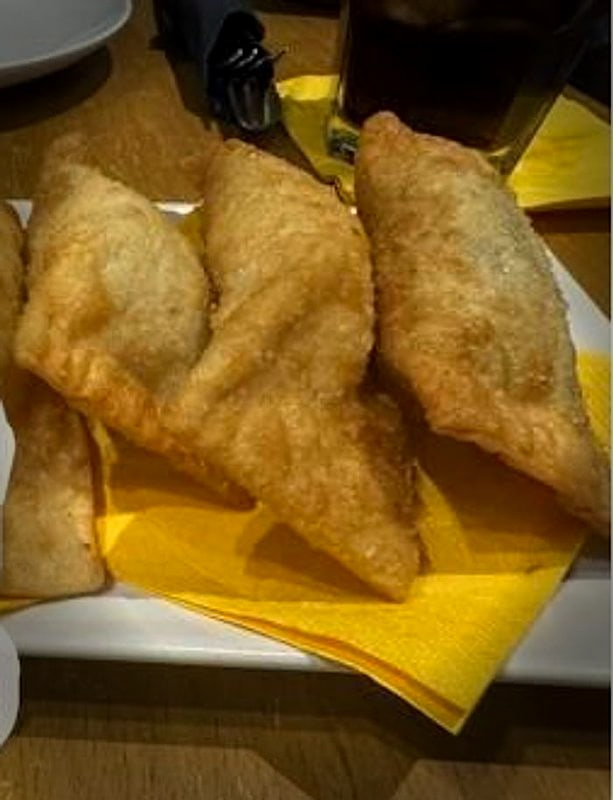Tre pastéis fritti sul tovagliolo giallo