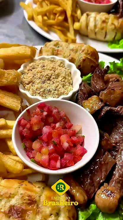 La porção al centro del tavolo: patatine, farofa, vinagrete, carne e pastéis